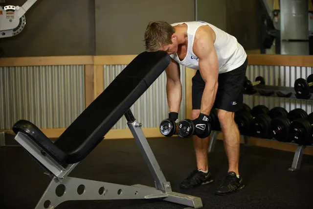 Bent Over Dumbbell Rear Delt Raise With Head On Bench, starting position