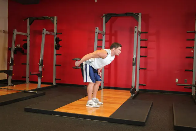 Standing Bent-Over One-Arm Dumbbell Triceps Extension, finishing position