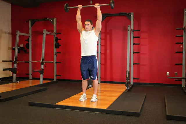 Standing Front Barbell Raise Over Head, finishing position